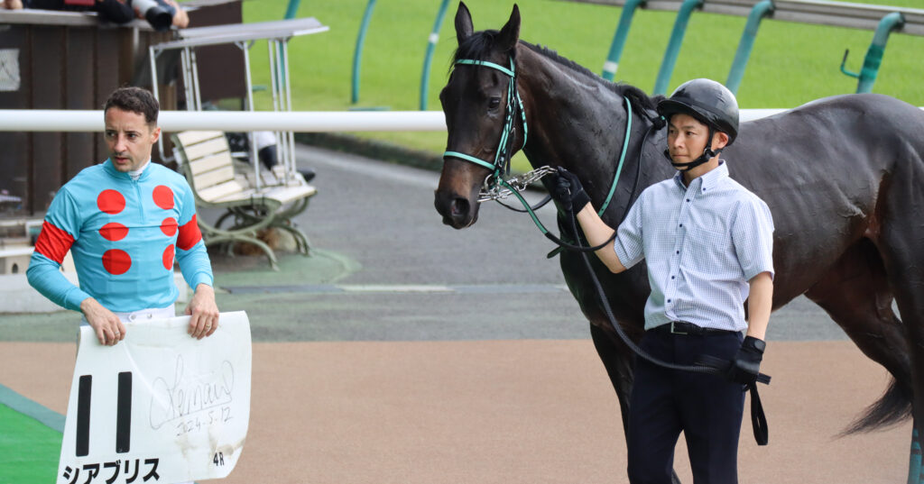 2024年5月12日東京競馬場の未勝利戦を勝利し、ウイナーズサークルでルメール騎手と並ぶ出資馬シアブリスの記念写真