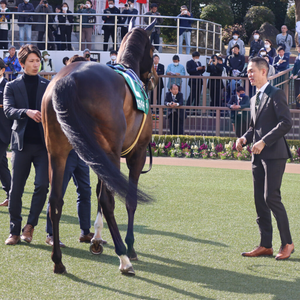 2024年3月16日中山競馬場のフラワーカップ、パドックで出資馬カンティアーモに笑顔で近づく木村哲也調教師の姿