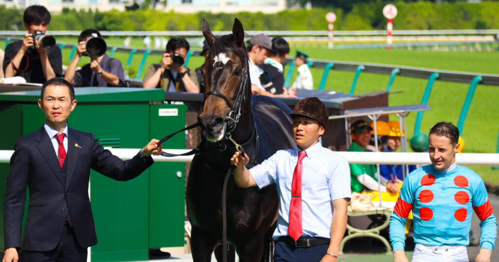 2024年5月18日東京競馬場のカーネーションカップで勝利し、ウイナーズサークルでルメール騎手と木村哲也調教師と並ぶ出資馬カンティアーモ