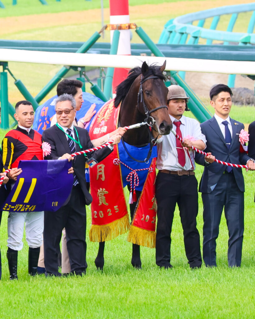 2025年4月20日撮影、中山競馬場の皐月賞表彰式で、ジョアン・モレイラ騎手や高柳大輔調教師に囲まれ優勝レイを掛けたミュージアムマイルの誇らしげな記念撮影写真