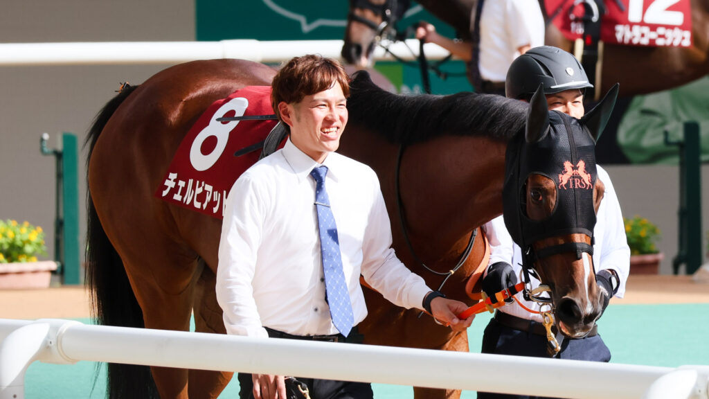 GⅡローズステークス当日、阪神競馬場のパドックを二人引きで歩くチェルビアット。厩舎の方の笑顔が素敵な写真。