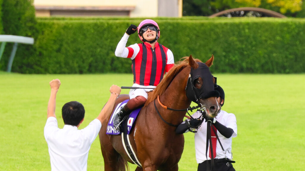 拳を突き上げる三浦皇成騎手と、両手で応える厩舎関係者。言葉を超えた喜びが中山の空に響いた、GⅠ初勝利のドラマ。